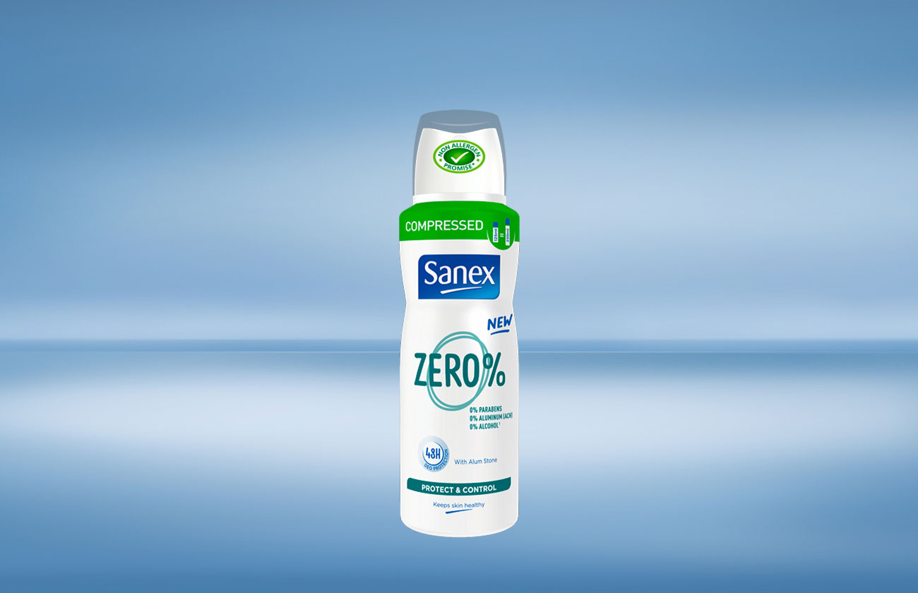 Een Sanex Zero% 'compressed' spuitbus deodorant met groene accenten, tegen een blauwe achtergrond.